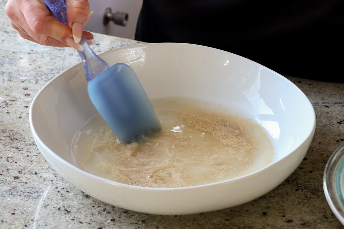 stirring sugar and yeast into the water