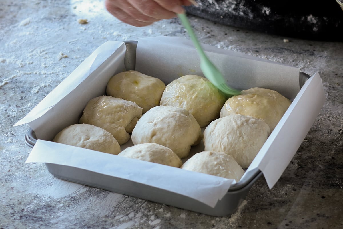 brushing the tops of the dinner rolls with oil