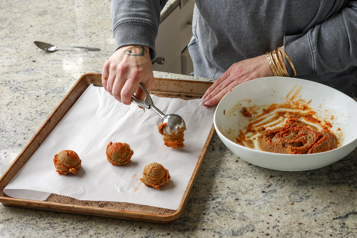 scooping gochujang caramel cookies onto the cookie sheet