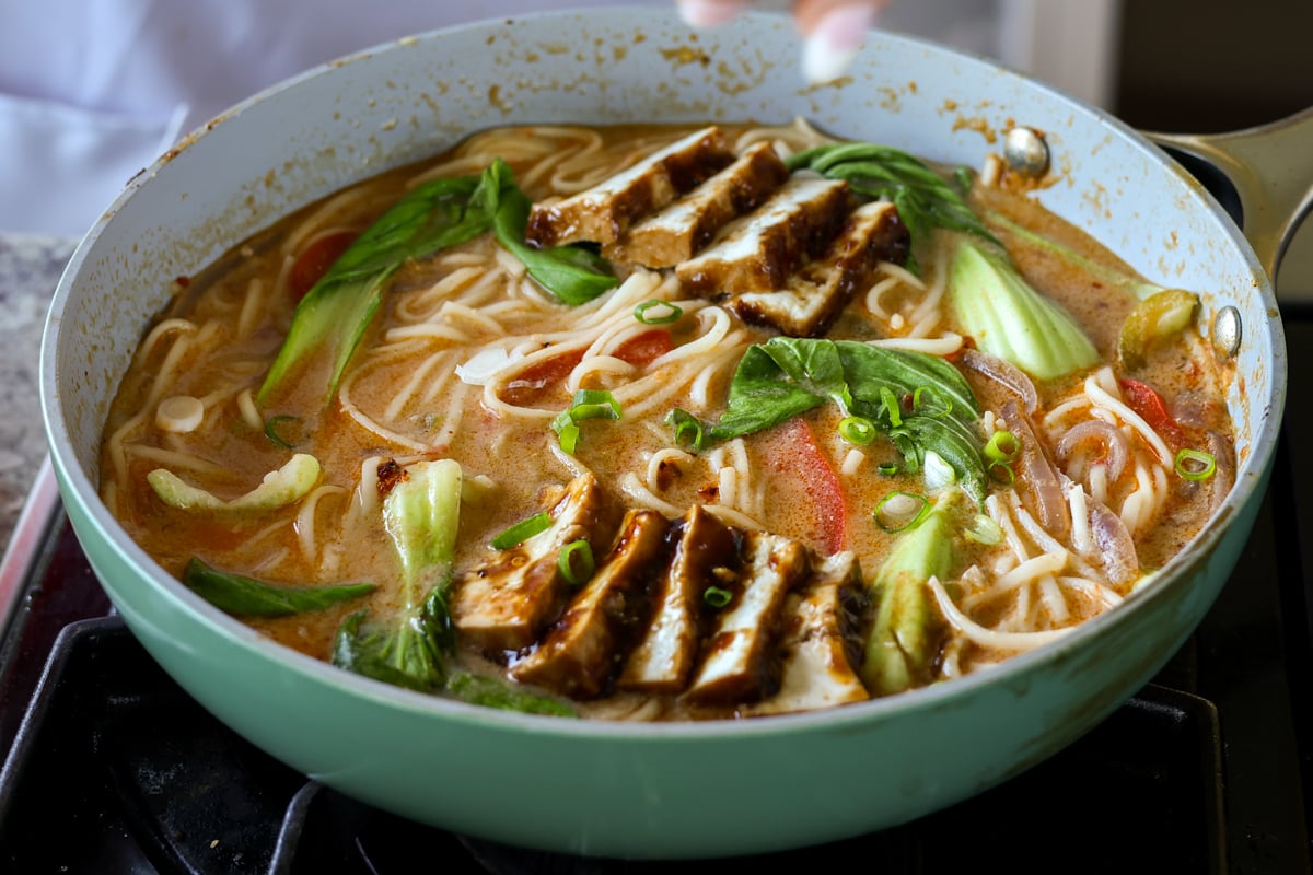 adding the tofu to the pan of tahini ramen