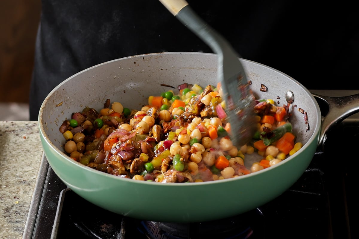 mixing the pot pie filling in the pan