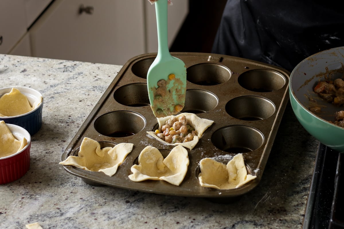 filling puff pastries in the muffin tin