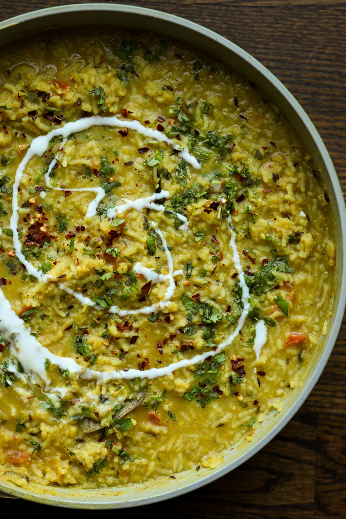 close-up of prepared khichdi in the pan with non-dairy yogurt swirl