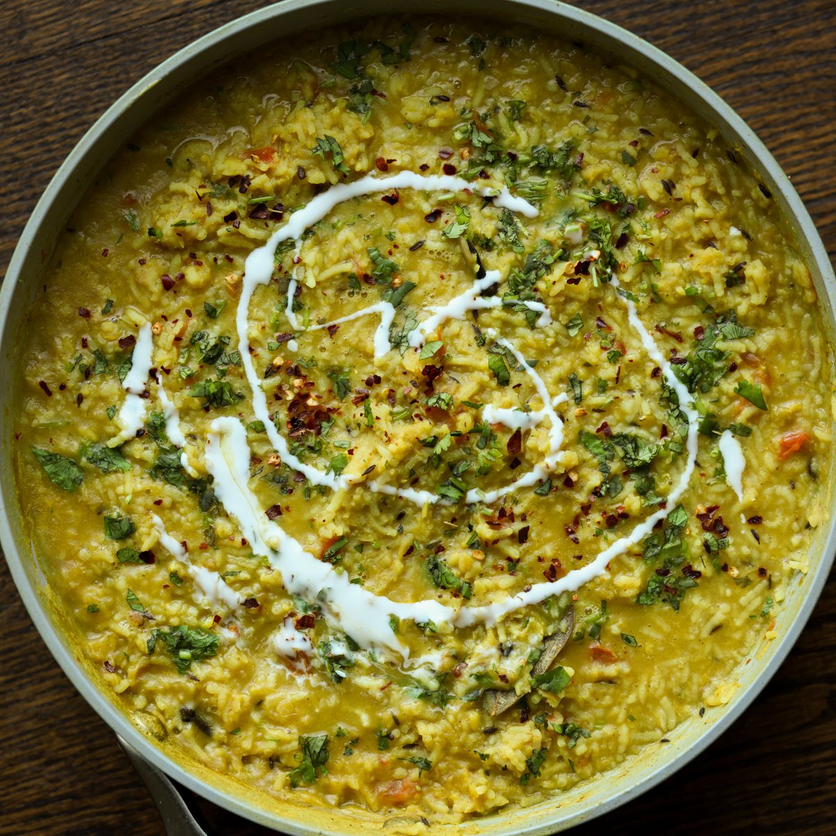 prepared khichdi in the pan with non-dairy yogurt swirl