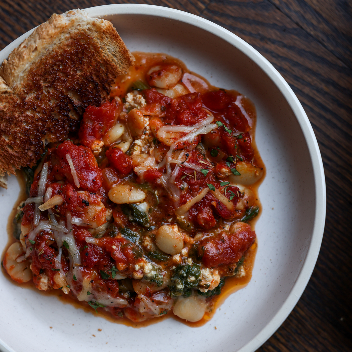 butterbean parmigiana on a plate with toasted sourdough
