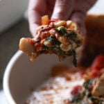 hand scooping up butterbean parmigiana