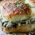 close-up of cheesy mushroom sliders on the baking sheet after baking