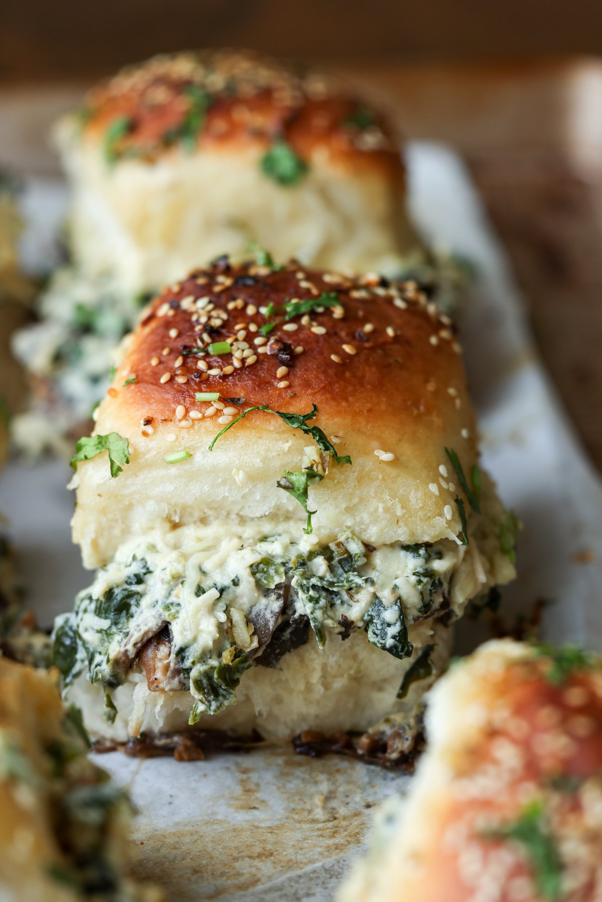 close-up of cheesy mushroom sliders on the baking sheet after baking