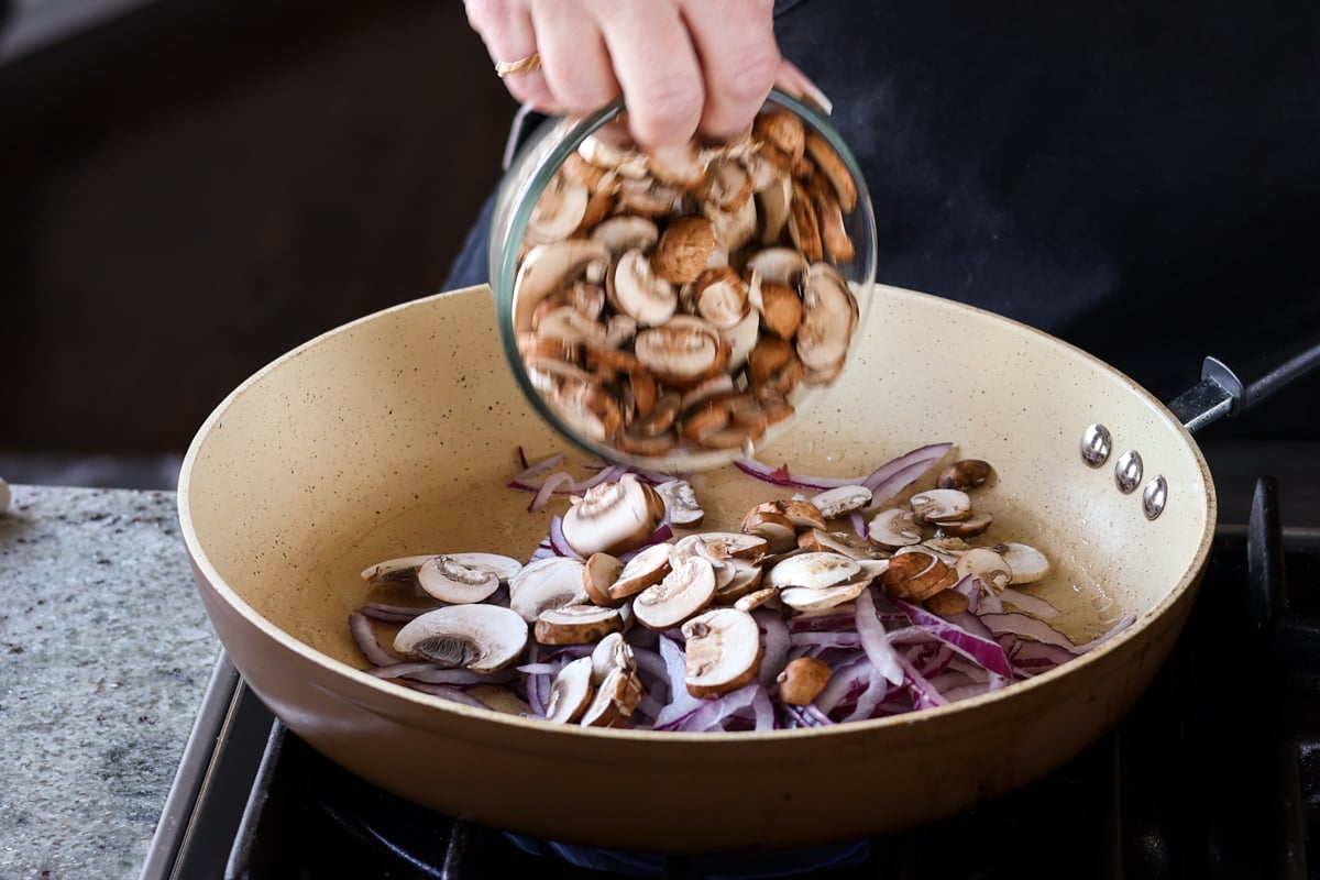 adding mushrooms to the pan
