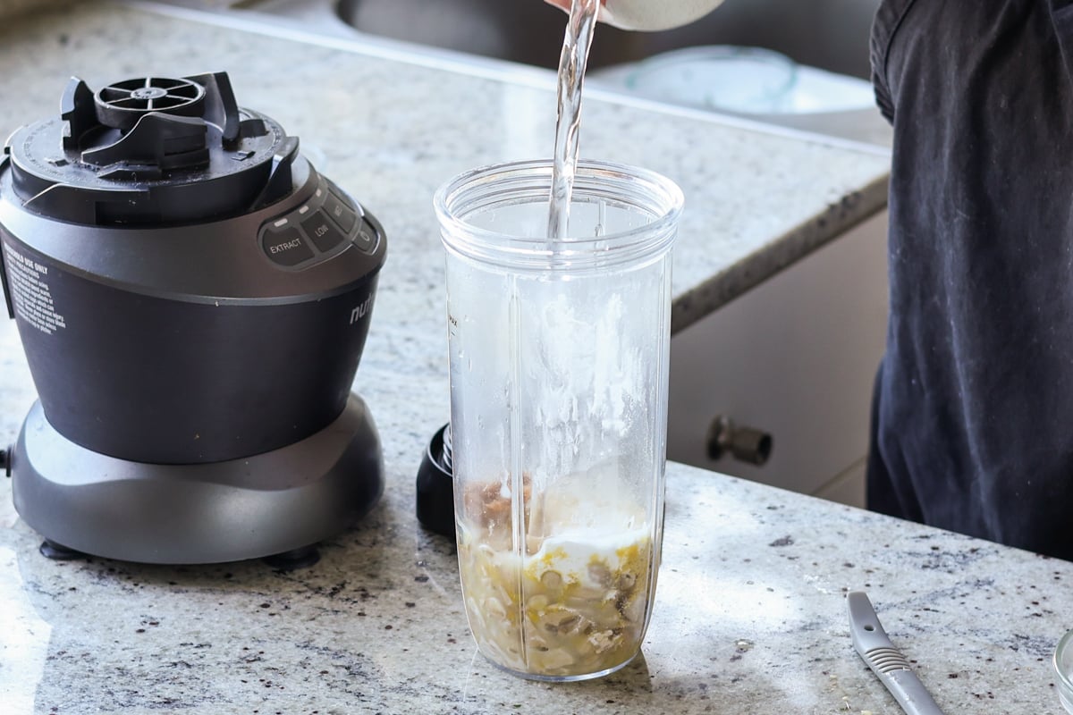 adding cashew cream ingredients to the blender