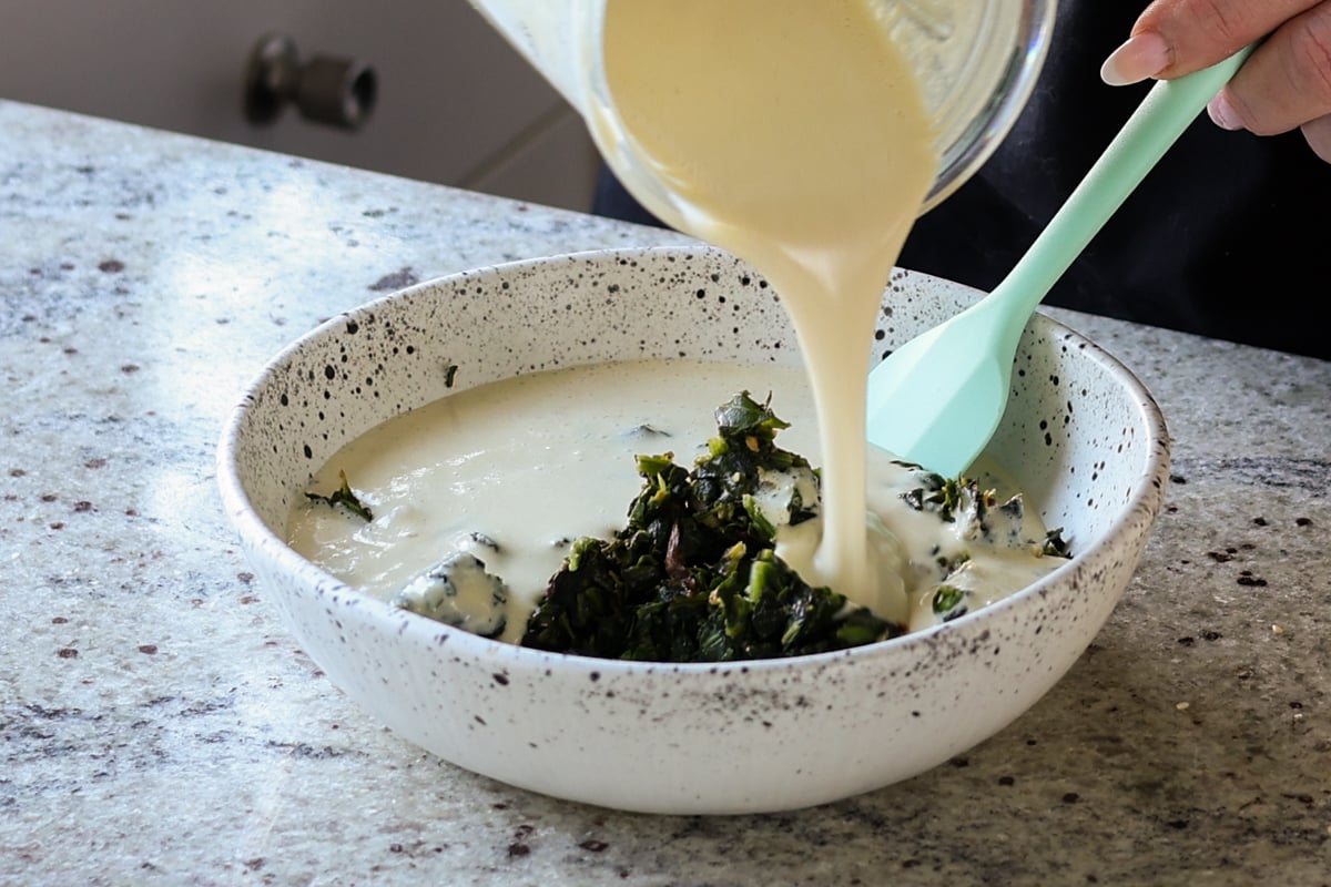 adding cashew cream to the spinach