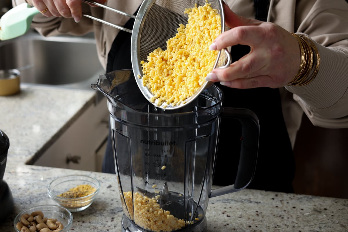 adding drained yellow lentils to the blender
