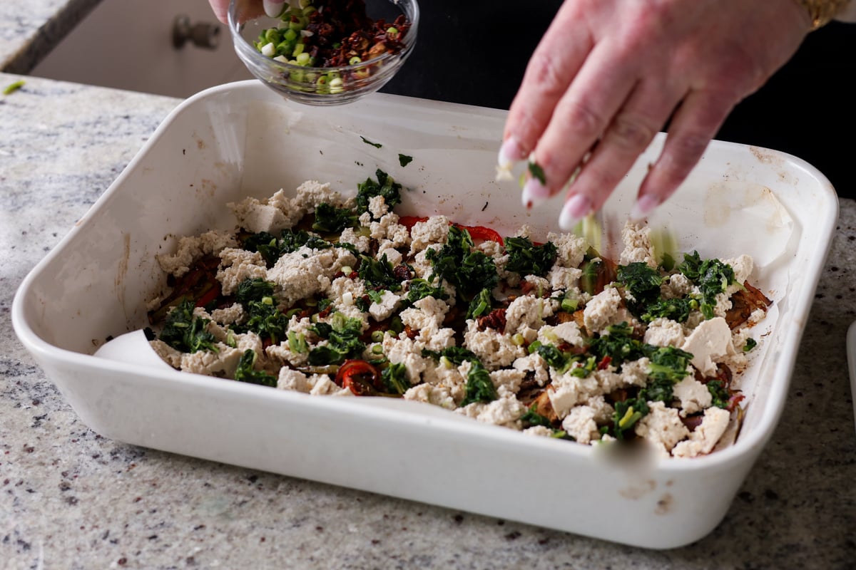 adding remaining veggies to the pan of roasted vegetables