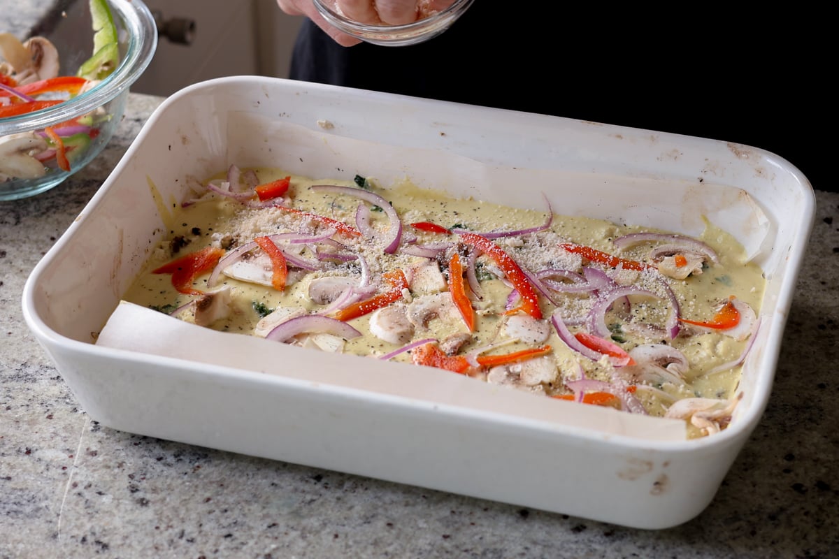 adding veggies on top of the frittata