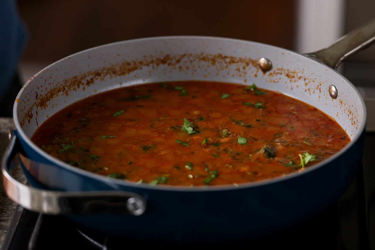 adding cilantro to the top of the stew