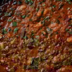 extreme close-up of lentil bean stew in the pan after cooking and garnishing