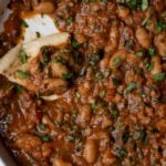 flatbread piece in a bowl of lentil bean stew