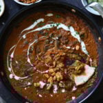 balchao mushrooms in the pan with a piece of flatbread dipped into it next to a bowl of crispy beans