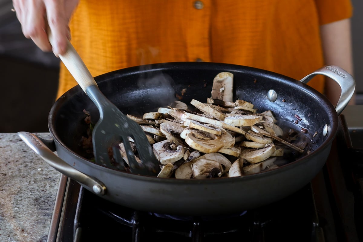 adding mushrooms to the pan