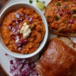 beans korma on a plate with bread and onions