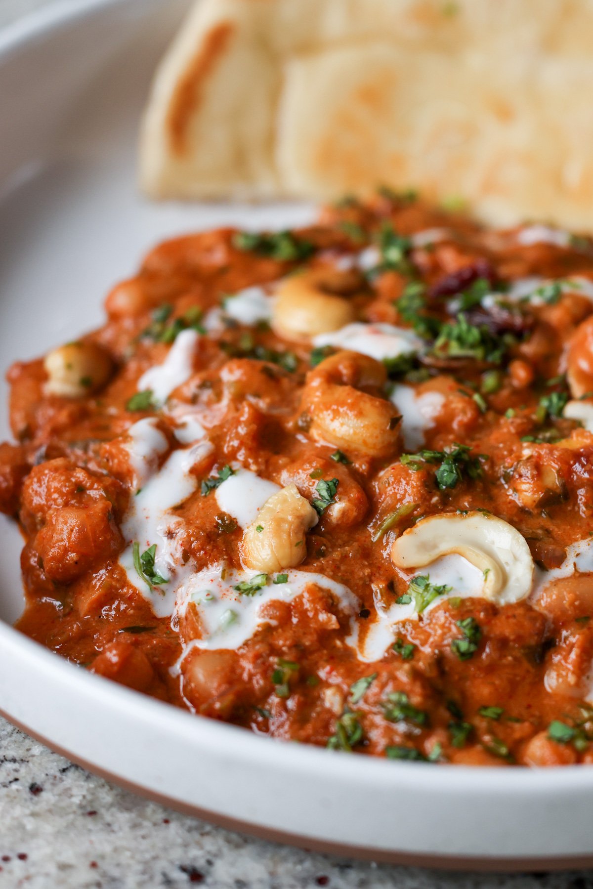 close-up of beans korma in a bowl with flatbread