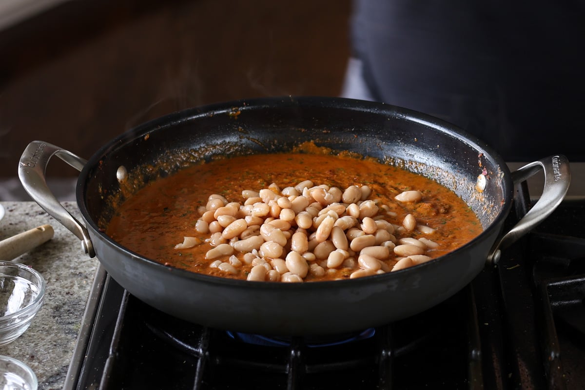adding beans to the korma sauce