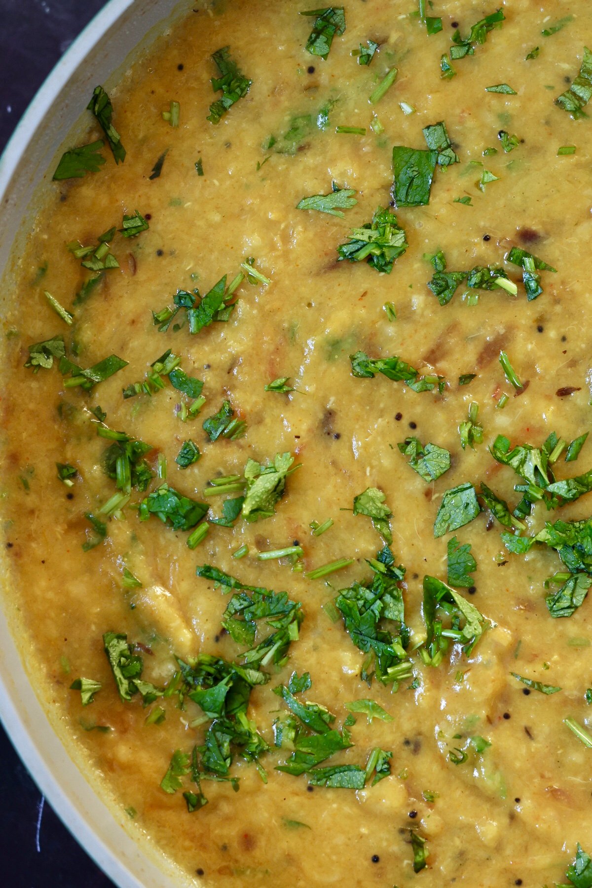 close-up of dal fry in the pan topped with fresh cilantro