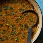 ladle in a panful of lentil and spinach soup
