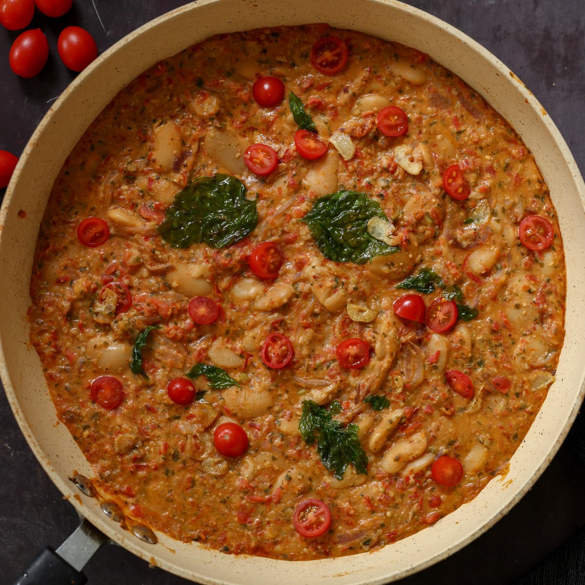 sicilian pesto sauce butter beans in the pan topped with crispy basil