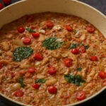 close-up of sicilian pesto sauce butter beans in the pan topped with crispy basil