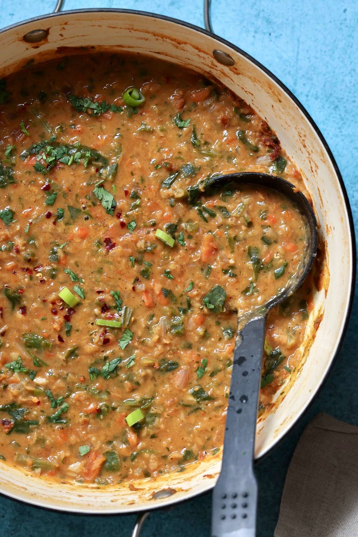 red lentil spinach soup in the pot with a ladle