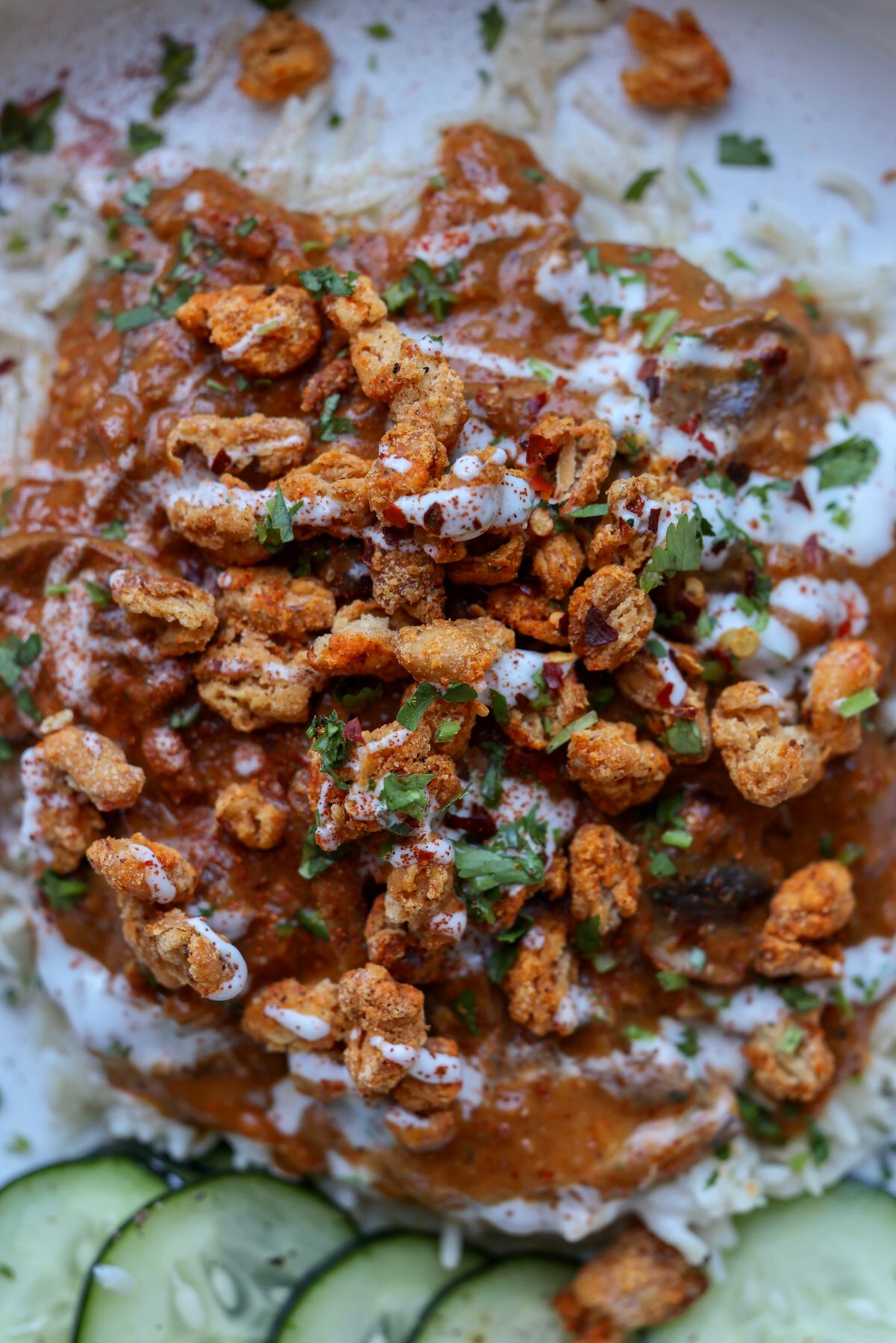 close-up of a bowl of balchao mushrooms topped with crispy beans and non-dairy yogurt