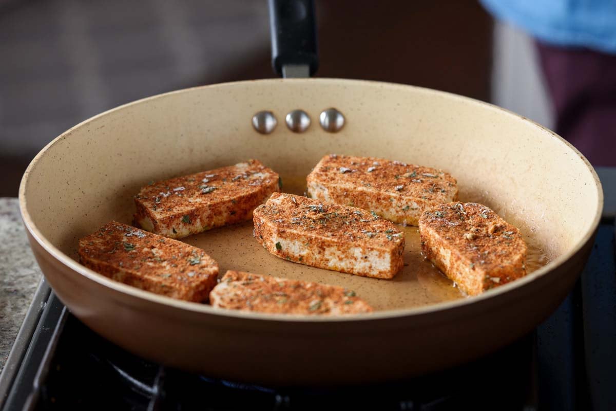 adding tofu to the pan
