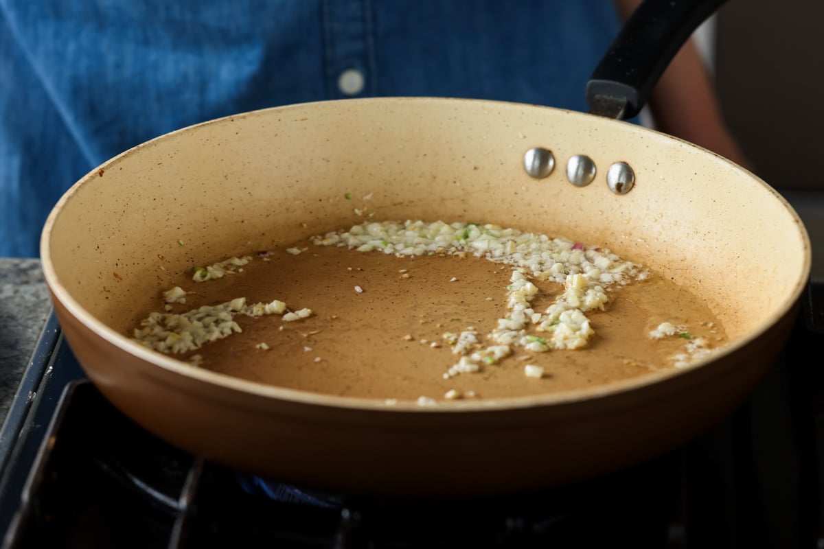 adding garlic to the pan