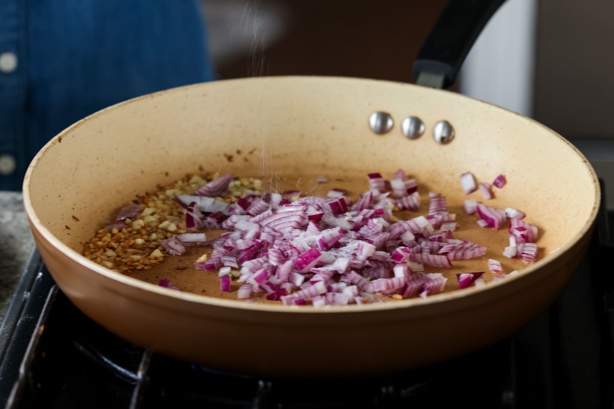 adding onion to the cooked garlic