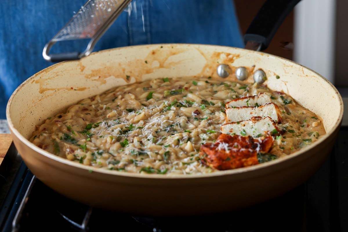 garlic parmesan orzo in the pan with the crispy tofu
