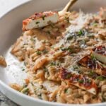fork taking a bite of garlic parmesan orzo