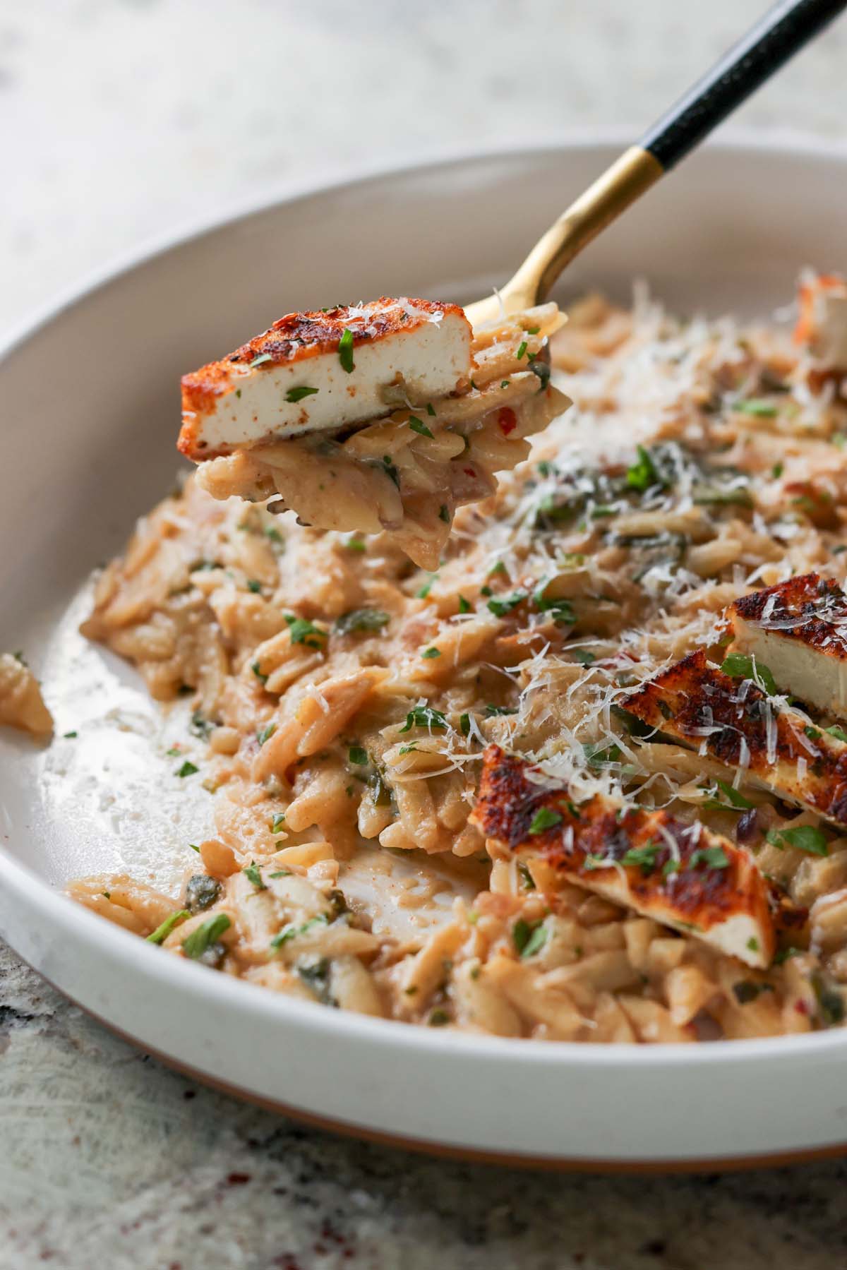fork taking a bite of garlic parmesan orzo