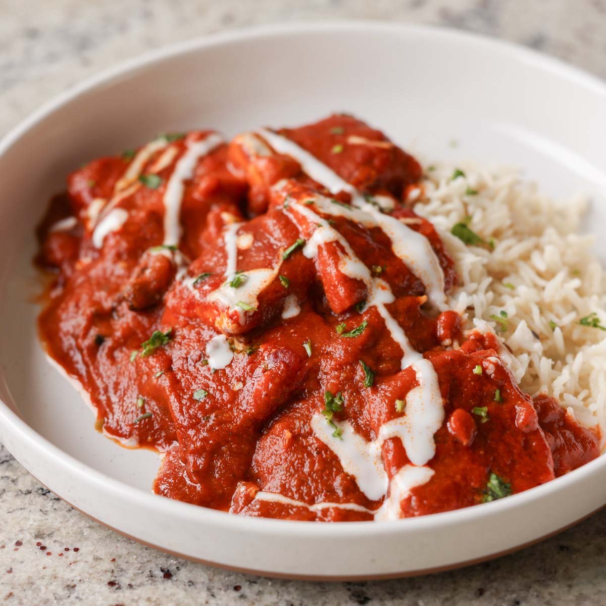 bowl of Kashmiri lal tofu and rice topped with non-dairy yogurt
