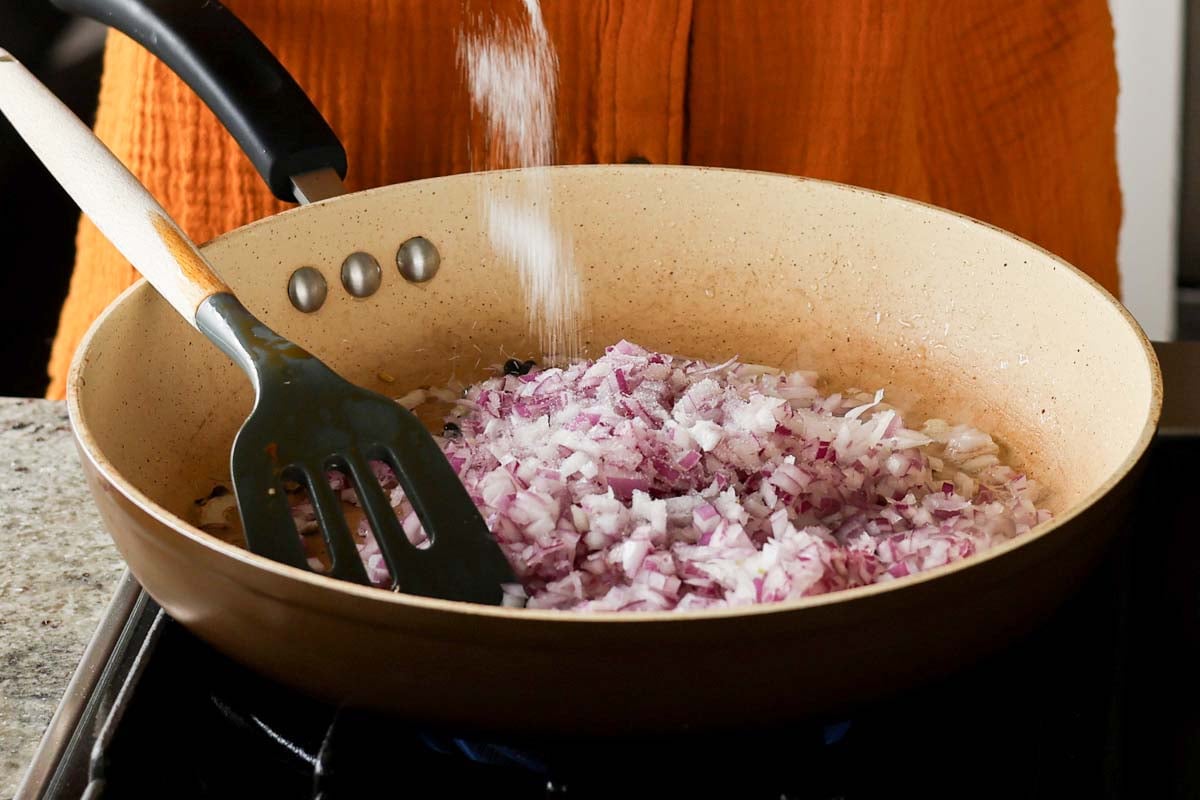 adding onion and salt to the pan