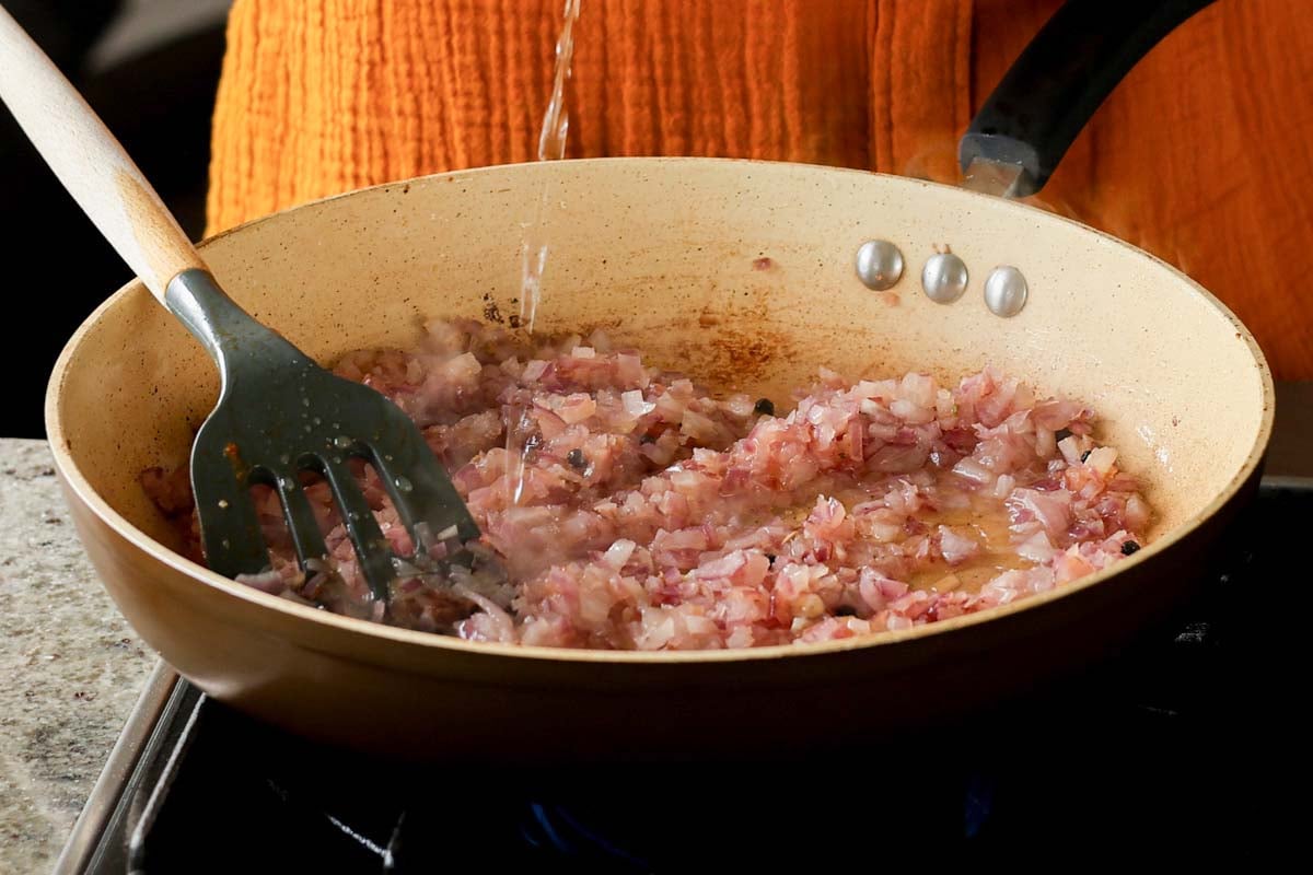 adding a splash of water to the onions