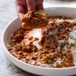 hand scooping up South Indian marry me lentils with flatbread