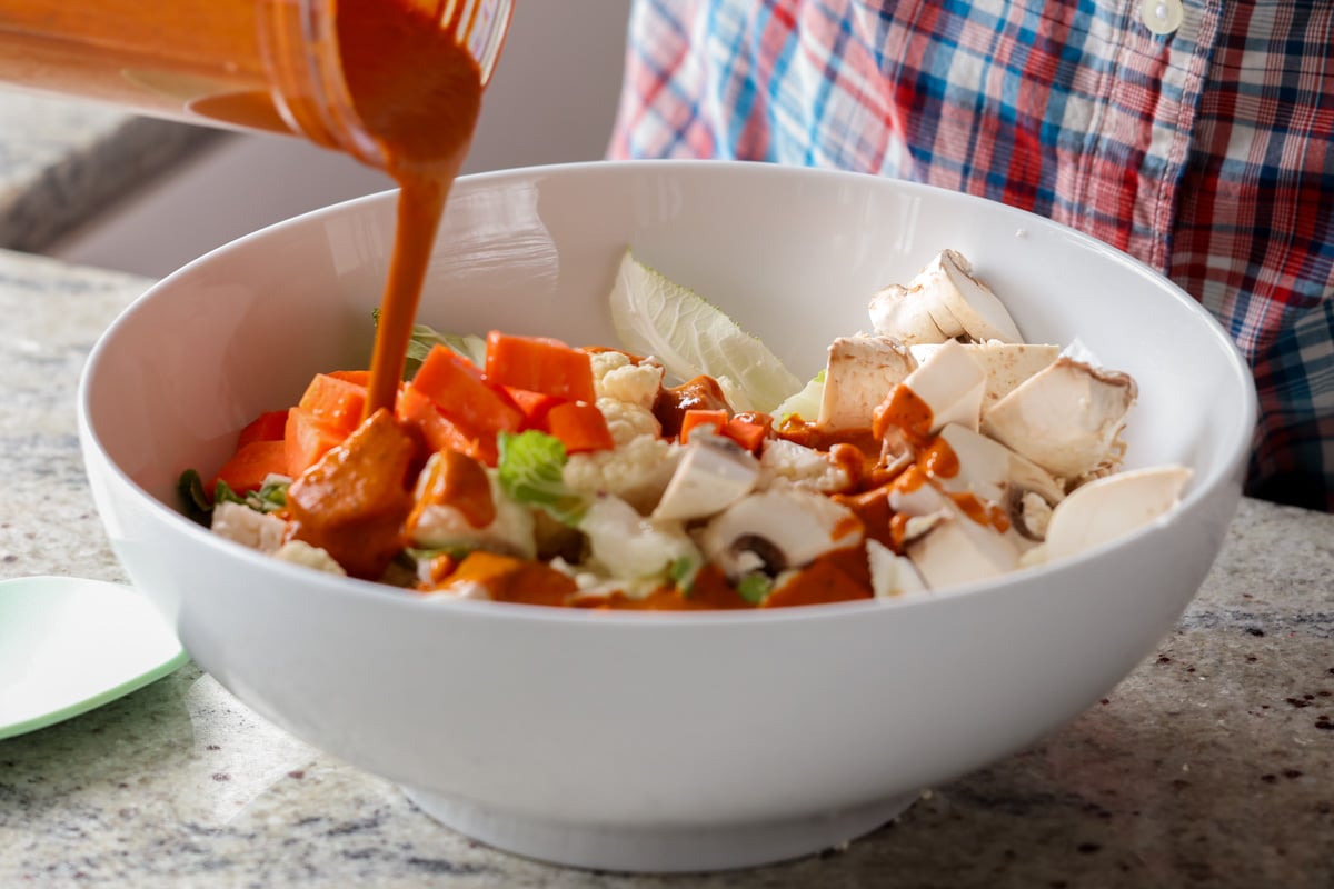 adding the spice paste to the bowl