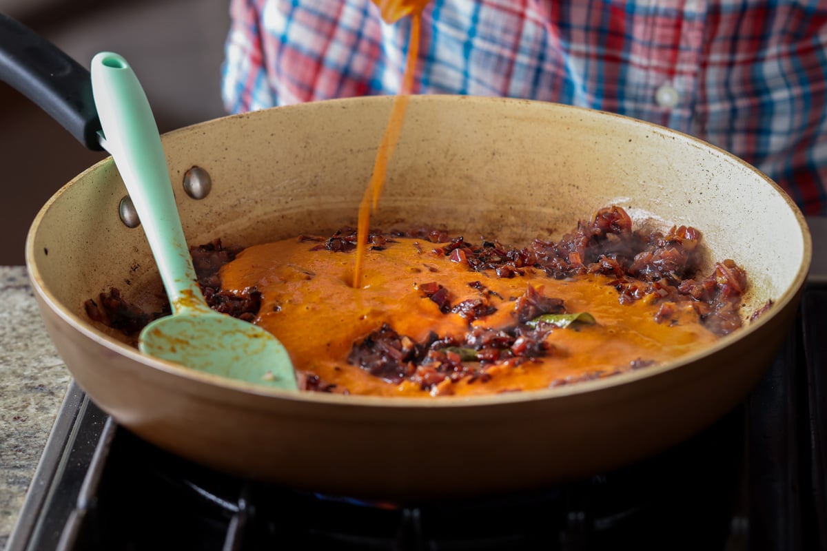 adding spice paste to the pan