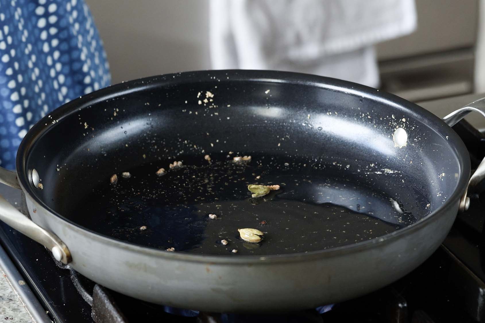 adding cardamom to the pan
