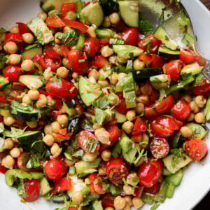 Balela chickpea cherry tomato cucumber salad in a white bowl