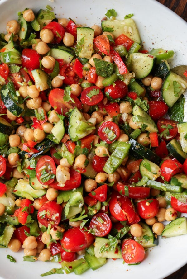 bowl of balela salad with a serving spoon