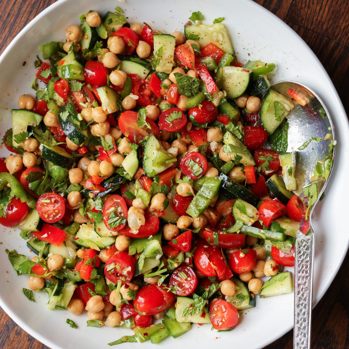 bowl of balela salad with a serving spoon