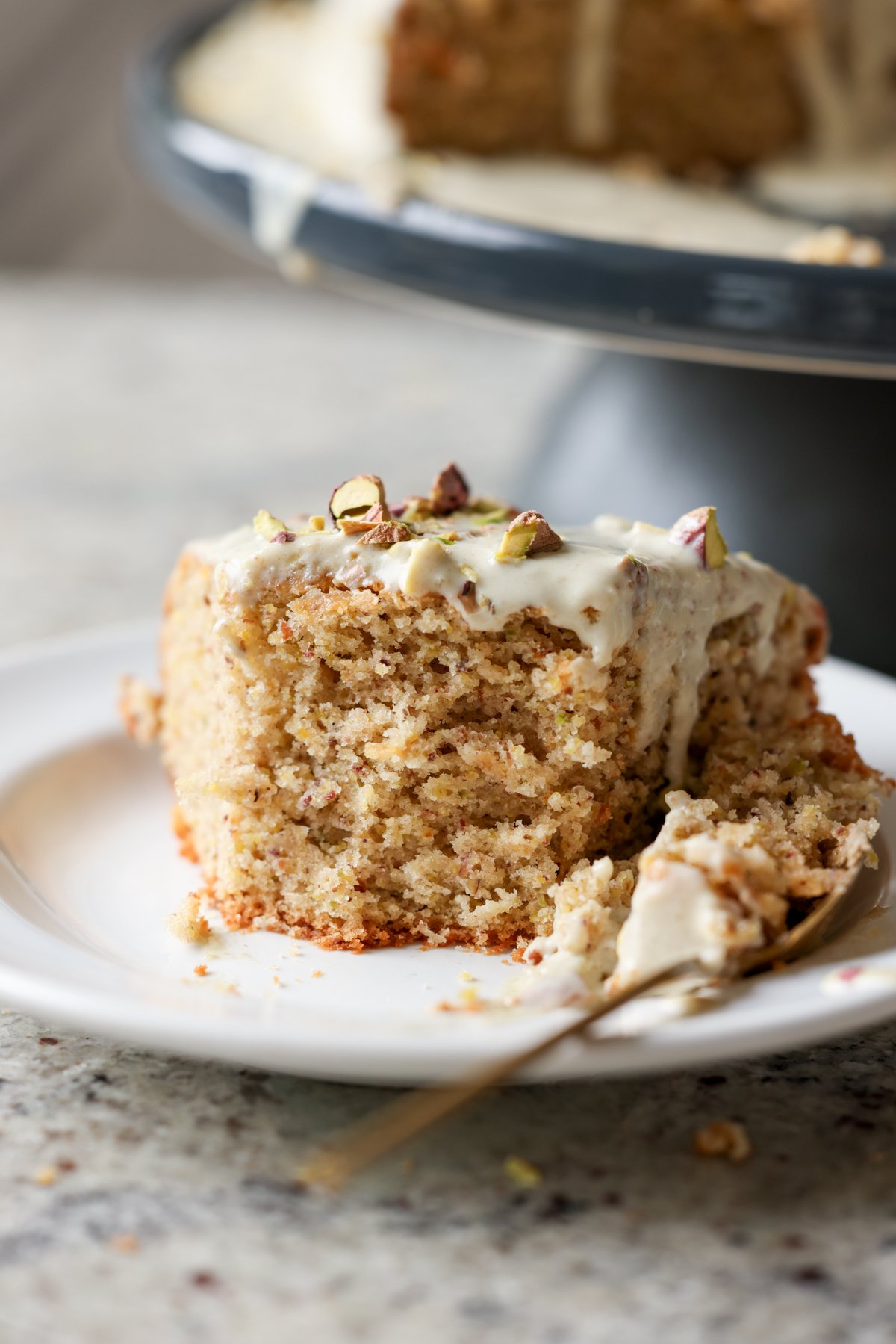 close-up of a slice of pistachio cake with a bite taken out