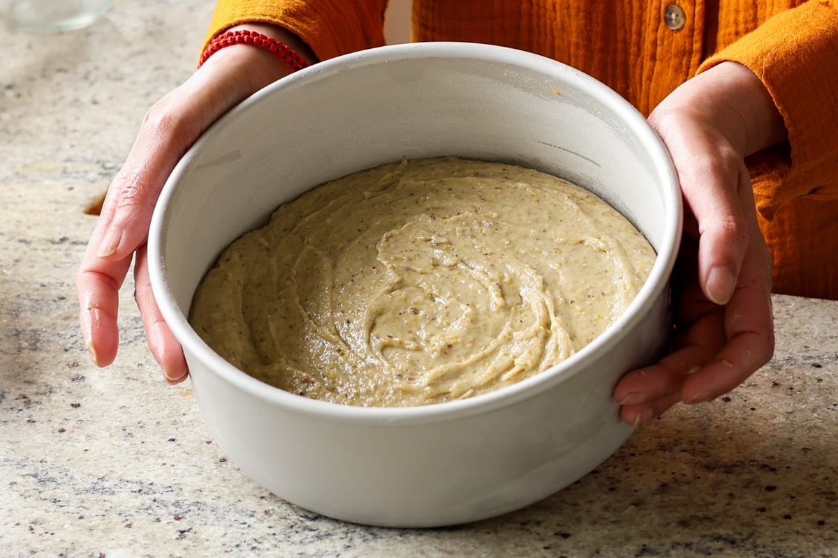 pistachio cake batter in the pan, ready to bake